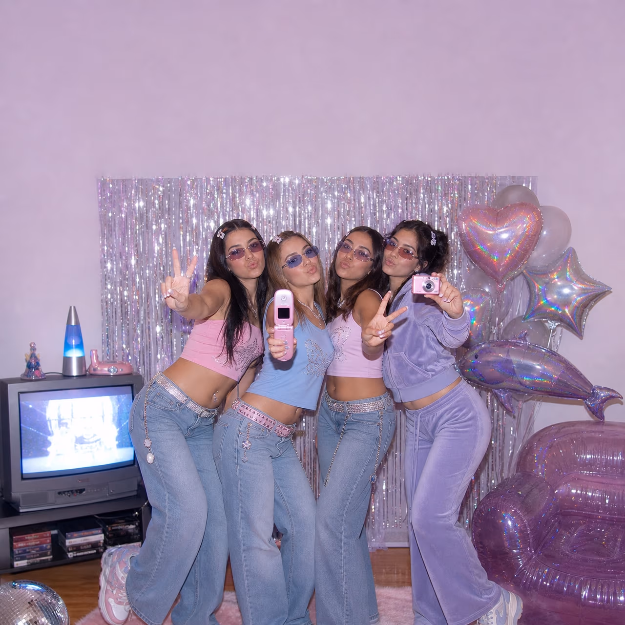 Amigos com looks dos anos 2000 posando juntos numa festa temática